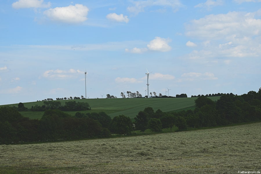 Mehrere Windräder auf einem Berg im Erzgebirge.