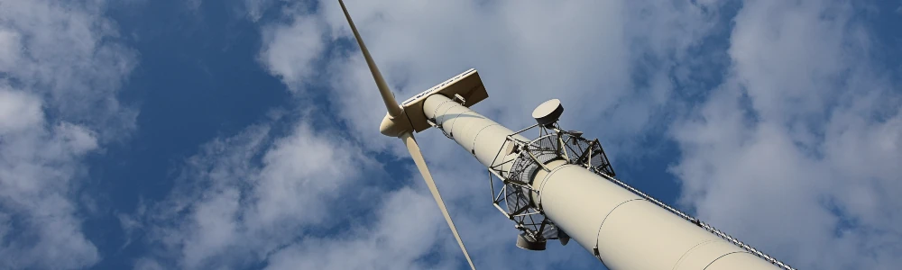 Windkraftanlage mit Mobilfunkantennen auf einem Berg.